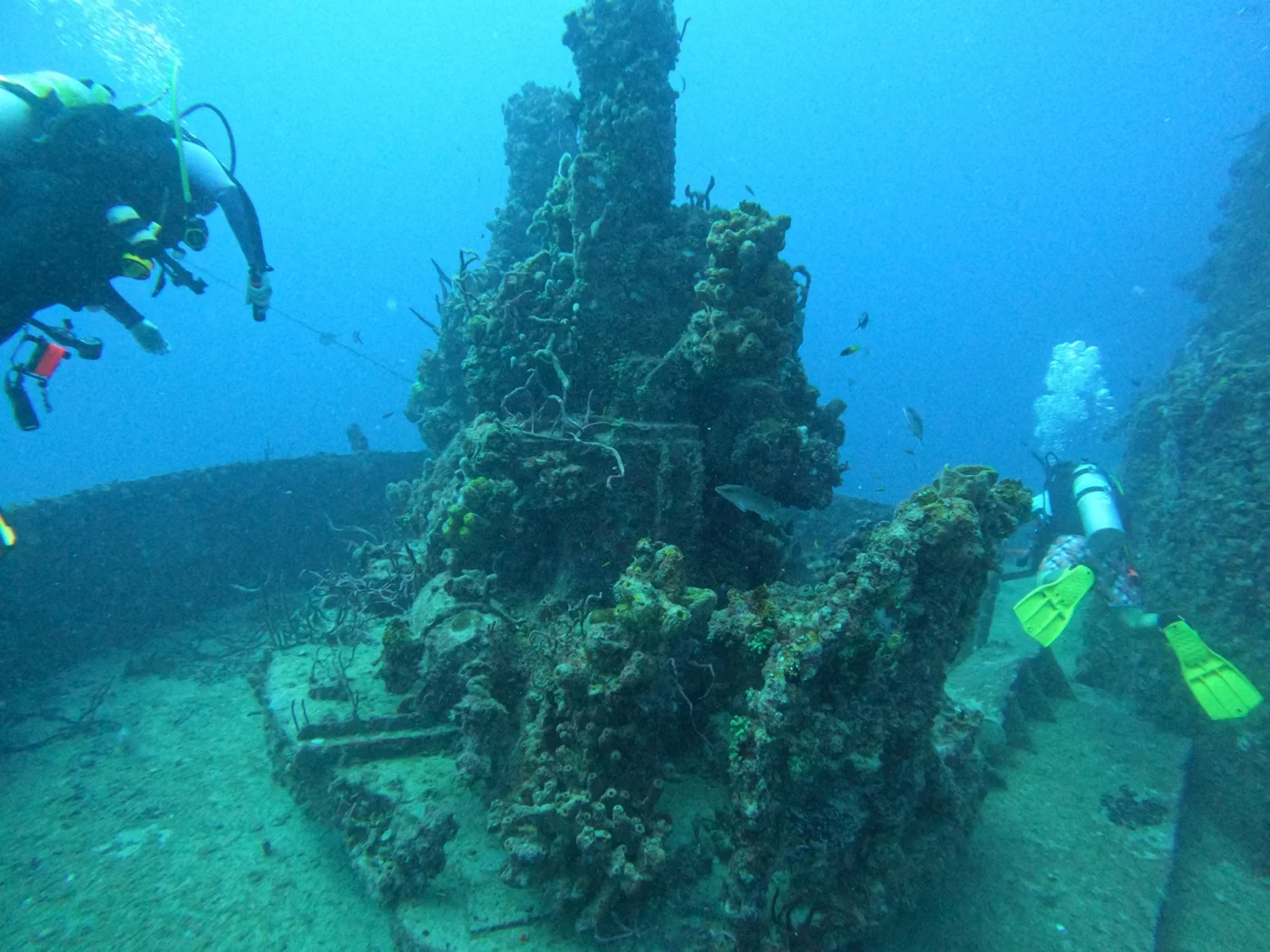 Divers beside marine-covered wreck structure in Key Largo